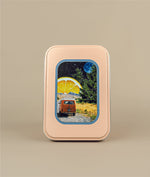 Image of travel tin with image of sleeper van with cedar trees and a lemon