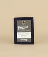 Charcoal and clay soap with a recycled paper tag held in place by a metal push pin 