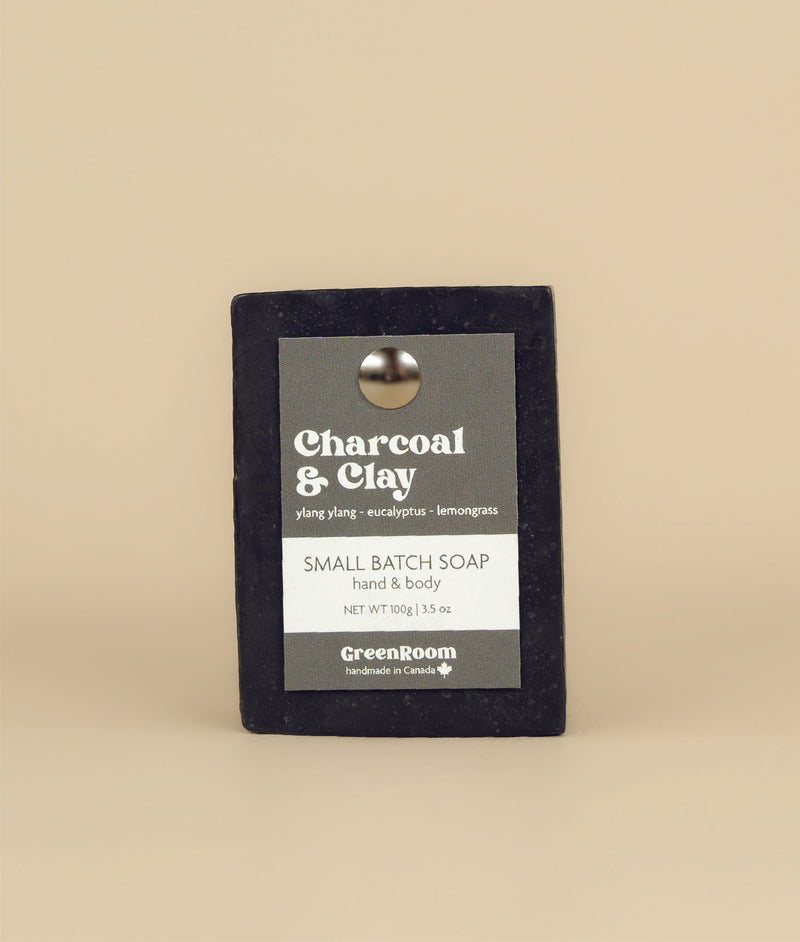 Charcoal and clay soap with a recycled paper tag held in place by a metal push pin 