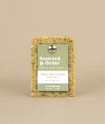 Seaweed and cedar soap with green and white recycled paper tag held up by metal push pin