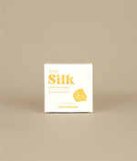 White with yellow writing small square sunny silk conditioner bar packaging