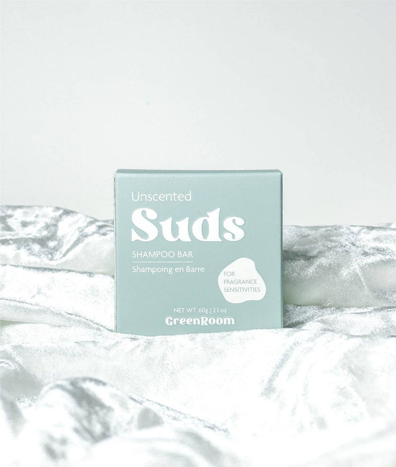 Small square Unscented suds shampoo bar blue packing on light blue velvet with a light blue back ground