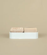 3D recycled plastic printed white soap dish With small pink floral suds and silk, shampoo and conditioner bars on top  of it