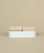 3D recycled plastic printed white soap dish With small pink floral suds and silk, shampoo and conditioner bars on top  of it
